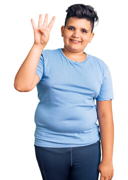 Little boy kid wearing sports workout clothes showing and pointing up with fingers number four while smiling confident and happy.