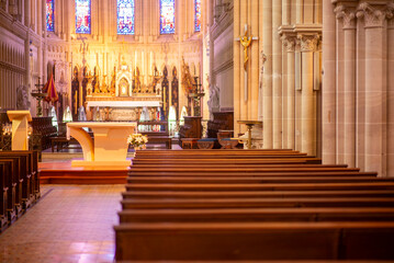 Serene gothic cathedral interior with empty wooden pews and stained glass