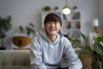 Fototapeta premium Happy young man. A joyful young man in a hoodie and beanie smiles broadly, conveying a positive and upbeat feeling.
