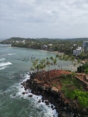 Stunning aerial view of Mirissa, Sri Lanka: a tropical paradise with palm-fringed beaches, vibrant blue waters, and picturesque coastline under clear, sunny skies.