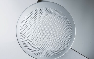 Circular pattern plate. White plate with a circular embossed pattern of small circles. The design creates a sense of depth and texture.