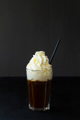 white cream with hot chocolate. Hot viennese coffee with whipped cream on dark background. American glass of black coffee or espresso. copy space. vertical