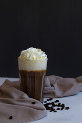 Cold frappe coffee with whipped cream. coffee cocktail in American glass with whipped cream on dark background. Alcoholic or non-alcoholic cocktail with liqueur, whiskey, white cream. copy space.