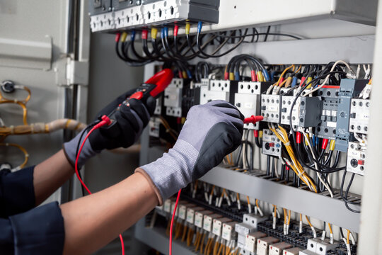 Electricity and electrical maintenance service,Electrical tests industrial electrical circuits with a multimeter in the control terminal box.
