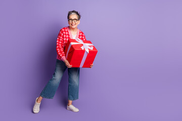 Full size photo of pretty retired female cheerful hold big present box wear trendy red outfit...