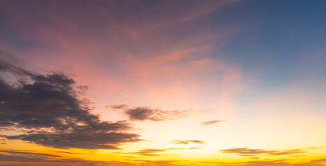 Naklejka premium Colorful clouds and sky. Dusk and sunset. Evening clouds with orange, yellow, pink and red sunlight and amazing storm clouds in the dusk sky. 