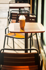 Iced coffee on a table outside the cafe and morning sunlight,Summer, vacation and iced coffee...