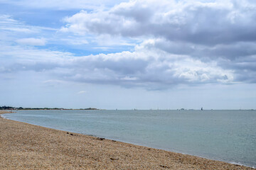 deserted beach at Browndown Hampshire England with blue sky and clouds in the background
