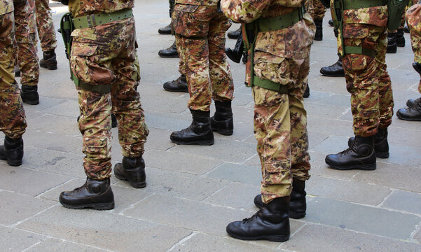 combat boots of army soldiers in camouflage uniforms standing in formation