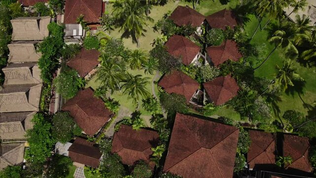 Aerial Drone Footage of Tropical Beachside Resort with Pool and Palm Trees.