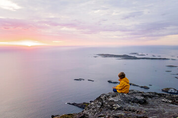 Family with children and pet, hiking Sukkertoppen trail on Senja island, Norway