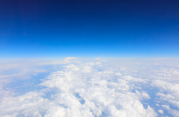 aerial view of white clouds and blue sky from an airliner from above