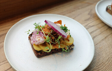 smorrebrod is a typical sandwich from Scandinavia filled with s herbs and onion