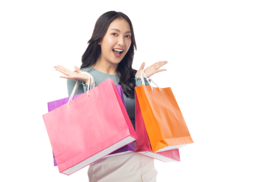 Cheerful young woman holding colorful shopping bags in both hands, expressing joy and excitement. Set against a clean white background, her enthusiasm captures the fun of a successful shopping spree