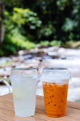 Lemon soda with sliced fresh lemon and Thai tea on the table.