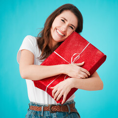 Woman, studio and excited with gift in box or package with smile, eyes closed and laugh on blue...