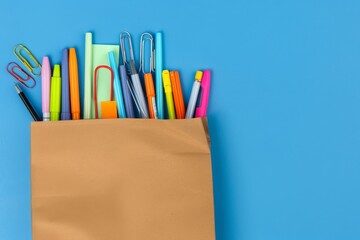 Fototapeta premium Colorful Pens and Paper Clips in a Paper Bag