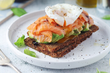 A rye bread sandwich with avocado and salmon