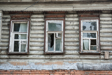 Abandoned building with shattered windows and distressed wooden exterior