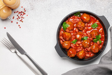 Meat or vegetable meatballs in tomato sauce with beans. Top view.
