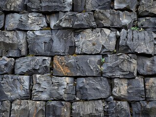 Fototapeta premium Textured stone wall displaying ruggedness, perfect for backgrounds, architecture, or nature-themed projects.