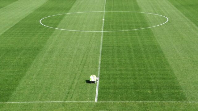 Groundsman painting white line on soccer field