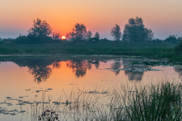 sunrise over the lake and field 
