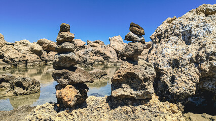 Beautiful view of the stone beach with stone pyramids.