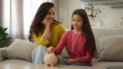 Caucasian family saving money adult woman female mom mother teaching little girl child kid save...