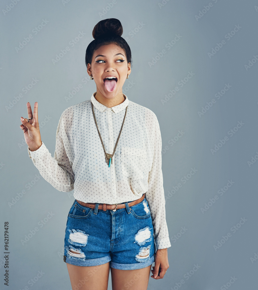 Wall mural Woman, peace and tongue out in studio for fashion, casual clothes and chic confidence for person. Female model, v and trendy accessory by gray background for stylish outfit, hipster and mockup space