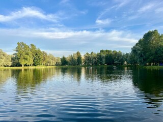 beautiful blue lake in the park, trees reflection on the lake surface
