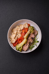 Bowl with slices of baked tuna with broccoli, tomatoes and fusili pasta