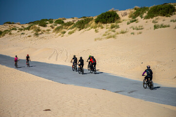 Cyclists on old road on Valdevaqueros Dune in Tarifa, Strait of Gibraltar, Spain
