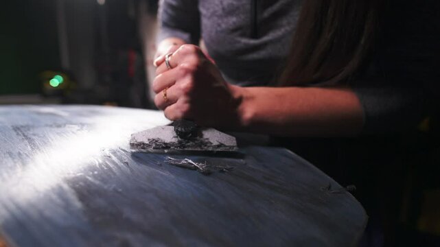Cleaning the snowboard surface from excess wax. Snowboard repair. Seasonal maintenance of ski equipment. Close-up