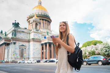 Young girl with long hair standing near St. Isaac's Cathedral in St. Petersburg. The concept of the...