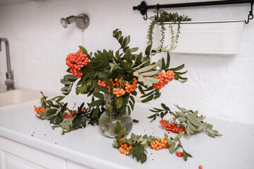 Fototapeta premium A Beautiful and Vibrant Floral Arrangement Featuring Colorful Berries and Lush Leaves