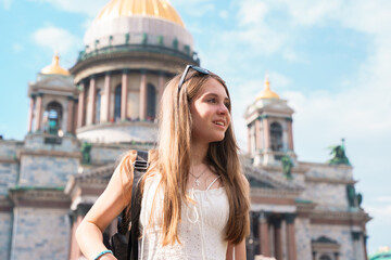 Young girl with long hair standing near St. Isaac's Cathedral in St. Petersburg. The concept of the tourist season, an active pastime.