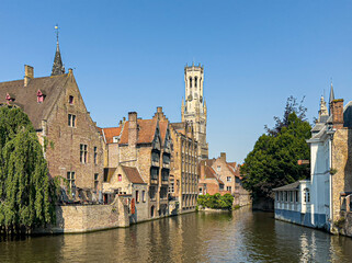 Brugge, Flanders, Belgium - June 25, 2024: Halletoren seen from Rozenhoedkaai and Dijver canal,