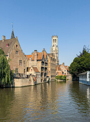 Brugge, Flanders, Belgium - June 25, 2024: Halletoren seen from Rozenhoedkaai and Dijver canal,