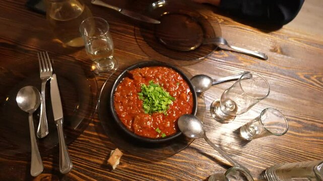On table there are cutlery and delicious chanakhi mlm ostri traditional Georgian stew with meat and vegetables