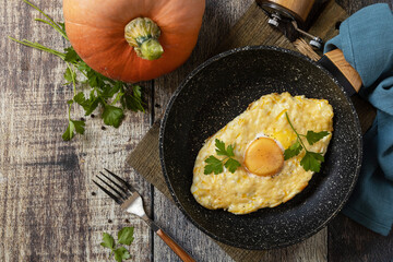 Khachapuri, baked cottage cheese pumpkin bread with cheese and egg filling on rustic wooden table.