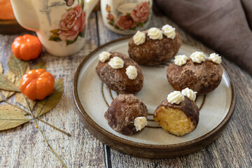 Chocolate rum potato cake with pumpkin on rustic background, homemade vegan dessert. Traditional Eastern European dish with cocoa and butter. Chocolate sweets filled with marzipan.