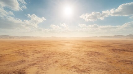 Naklejka premium A desolate, dry desert landscape with a clear blue sky and white puffy clouds. The sun shines brightly, casting long shadows on the ground.