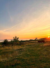 Sunset on field creates warm colors all over the sky