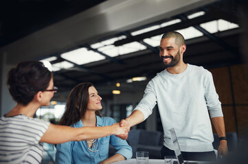 Happy man, handshake and women in startup for hiring, thank you or welcome support in meeting. Partners, workplace or designers for agreement on business deal, recruitment or opportunity for teamwork