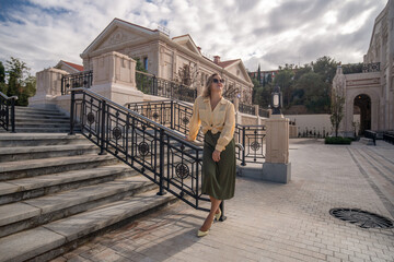 Woman Fashion Skirt Stairs - Woman in a stylish outfit poses on stairs in front of a classic...