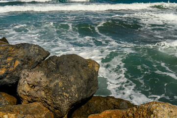 close up beautiful waves of the mediterranean sea breaking on rocks near the shore