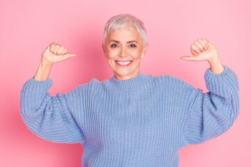 Photo portrait of attractive senior woman point self proud dressed stylish blue knitwear clothes isolated on pink color background