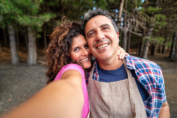 Cheerful Middle-aged Couple Taking Selfie in Forest, Happy Mature Relationship Outdoors