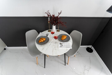 A round table with two chairs and two plates of food on it